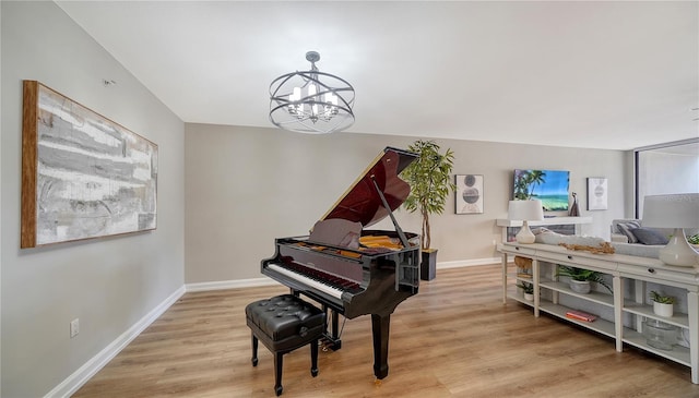 miscellaneous room with a chandelier and light hardwood / wood-style floors