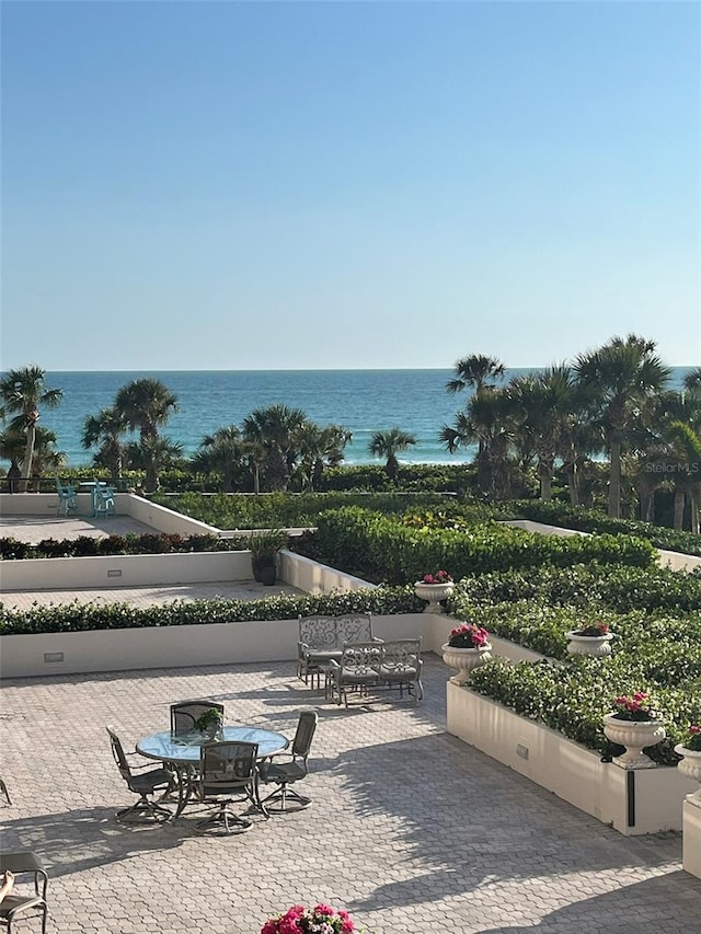 view of community with a water view and a patio area