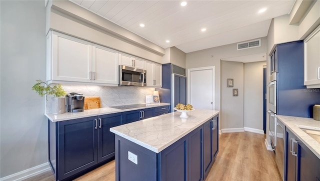 kitchen featuring light stone countertops, blue cabinets, a kitchen island, and appliances with stainless steel finishes