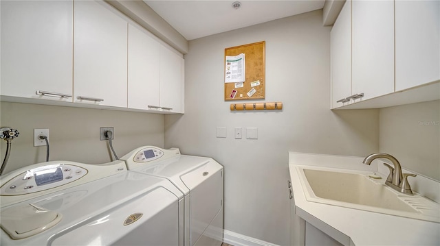 laundry room featuring washing machine and clothes dryer, sink, and cabinets