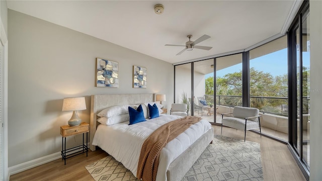 bedroom with floor to ceiling windows, ceiling fan, and light hardwood / wood-style floors