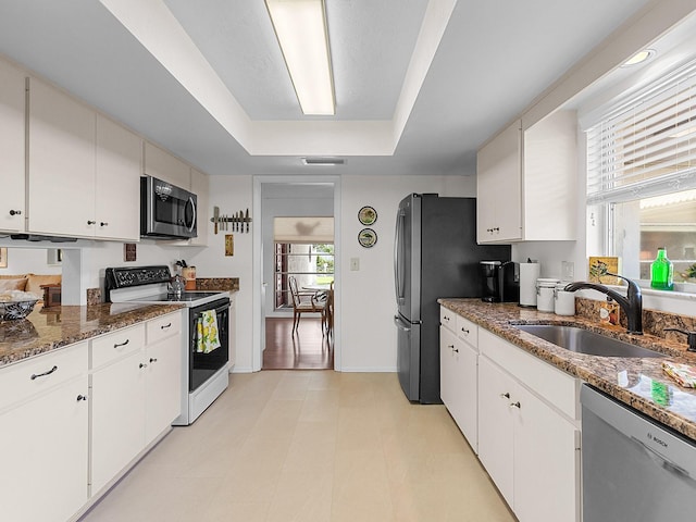 kitchen with white cabinets, stainless steel appliances, a healthy amount of sunlight, and sink