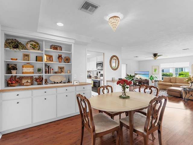 dining space with a textured ceiling, hardwood / wood-style flooring, and ceiling fan