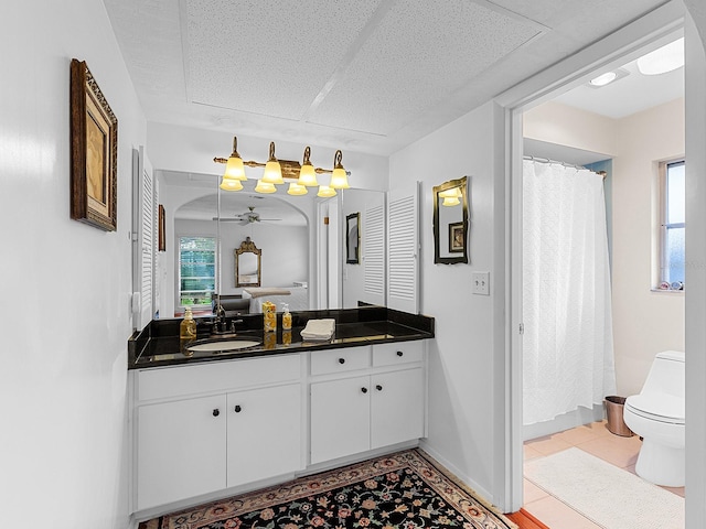 bathroom with toilet, vanity, tile patterned floors, and ceiling fan