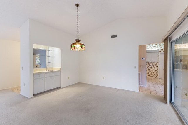 interior space with light carpet, sink, and vaulted ceiling