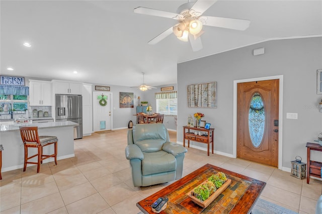 tiled living room with lofted ceiling and ceiling fan