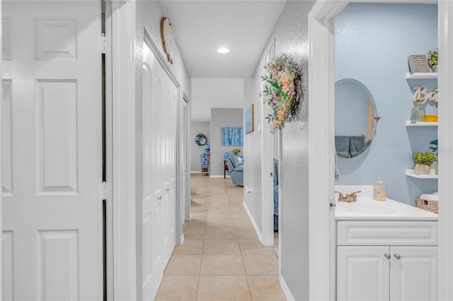 hallway featuring sink and light tile patterned floors