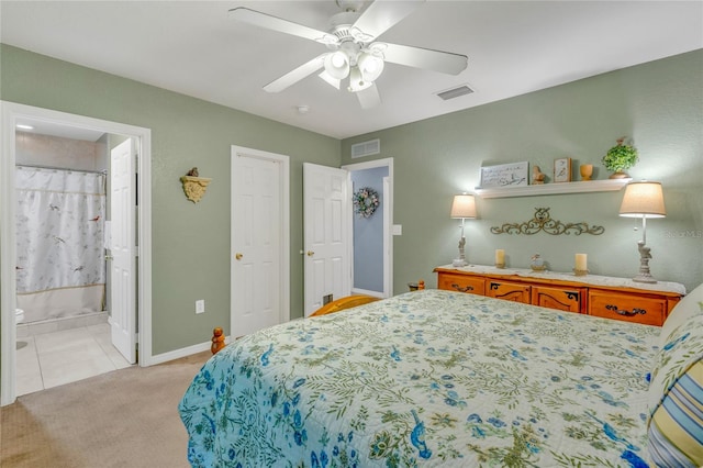 bedroom featuring ceiling fan, connected bathroom, and light colored carpet