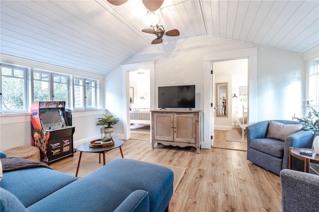 living room with plenty of natural light, ceiling fan, vaulted ceiling, and light hardwood / wood-style flooring