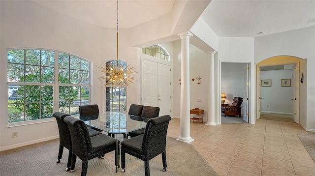 dining space with ornate columns, light tile patterned floors, and a chandelier