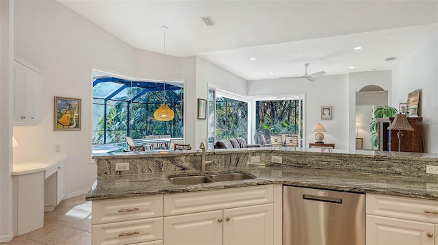 kitchen featuring dishwasher, stone counters, sink, ceiling fan, and light tile patterned floors