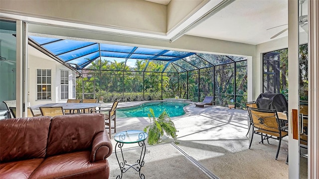 view of swimming pool with ceiling fan, a patio, and glass enclosure