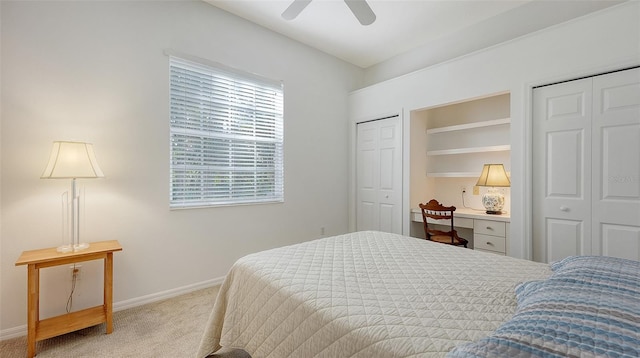 carpeted bedroom featuring multiple windows, ceiling fan, and multiple closets