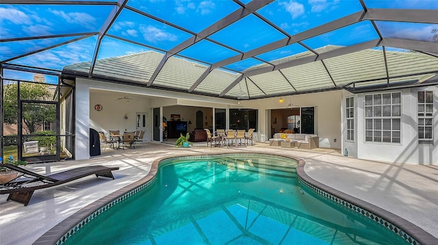 view of swimming pool featuring a patio area, ceiling fan, and a lanai