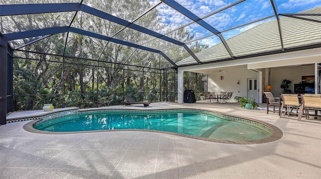 view of pool featuring a patio area, ceiling fan, and glass enclosure