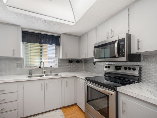 kitchen featuring a textured ceiling, white cabinetry, sink, and appliances with stainless steel finishes