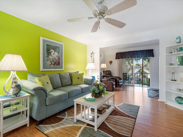 living room with hardwood / wood-style floors, ceiling fan, and ornamental molding