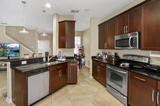 kitchen featuring dark brown cabinetry, sink, decorative light fixtures, and appliances with stainless steel finishes