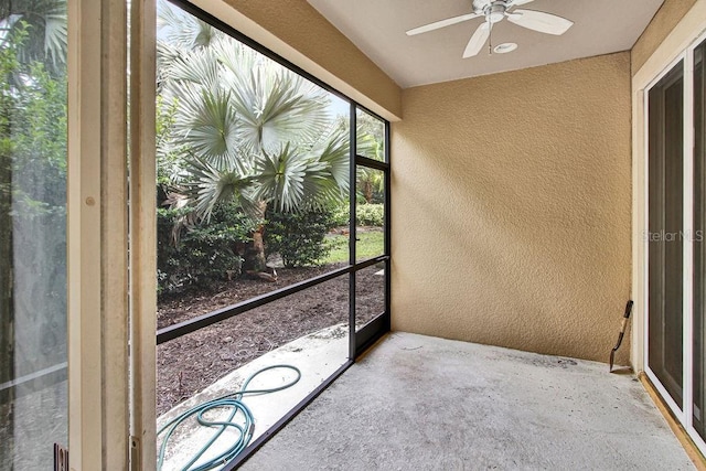 unfurnished sunroom featuring ceiling fan