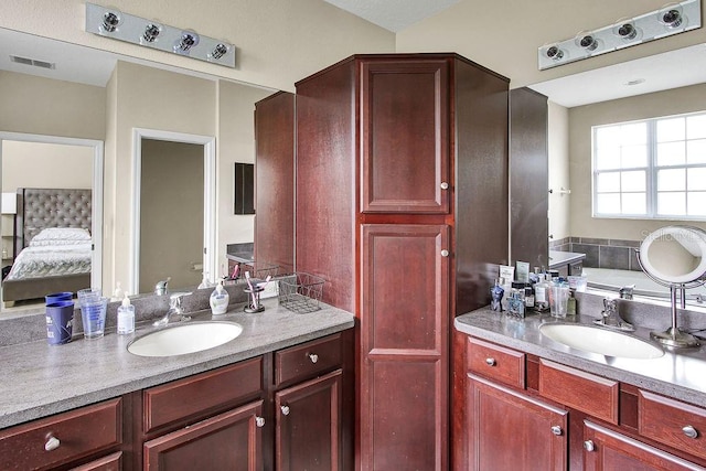 bathroom with vanity and a bath