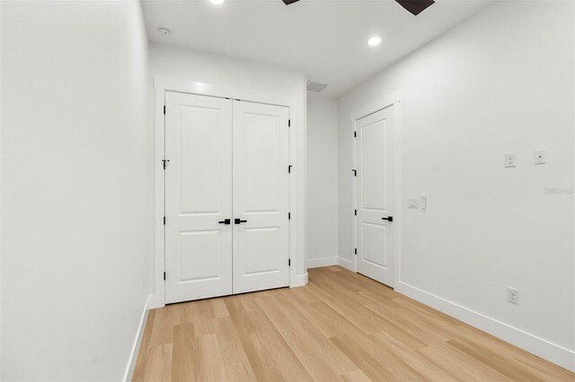 unfurnished bedroom featuring light wood-type flooring, a closet, and ceiling fan