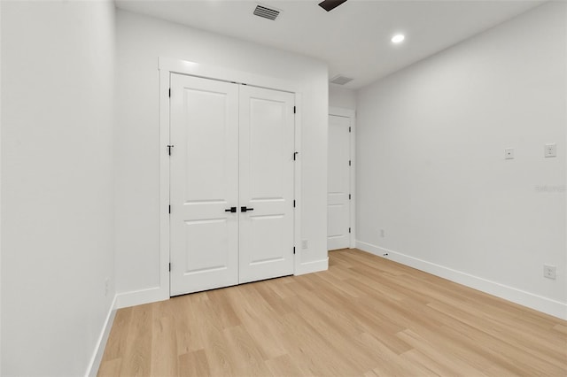 unfurnished bedroom with light hardwood / wood-style floors and a closet