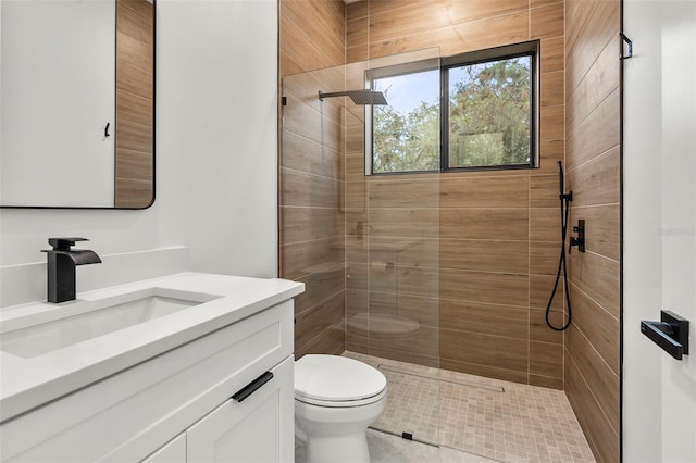 bathroom featuring tiled shower, vanity, and toilet