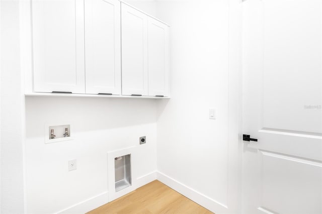 laundry area featuring electric dryer hookup, cabinets, hookup for a washing machine, and light hardwood / wood-style flooring