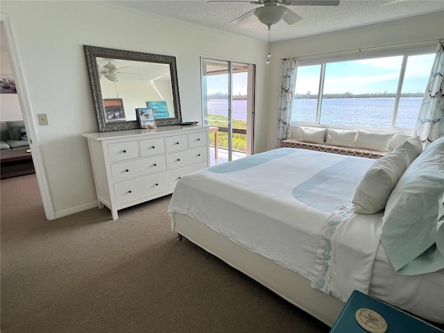 carpeted bedroom with access to exterior, a textured ceiling, a water view, and ceiling fan