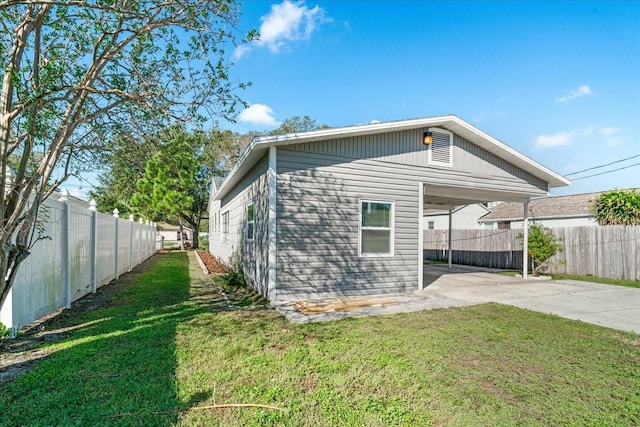 view of side of property with a carport and a lawn