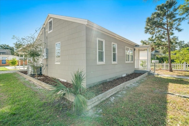 view of property exterior featuring central AC and a lawn