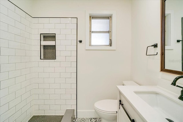 bathroom featuring a tile shower, tile patterned floors, vanity, and toilet