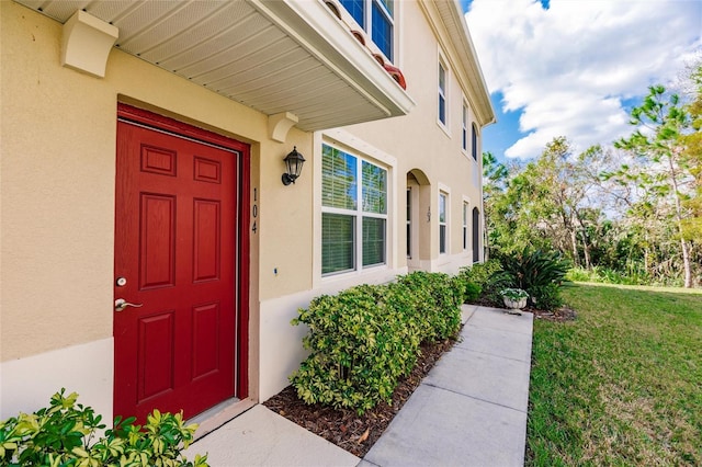 doorway to property with a yard