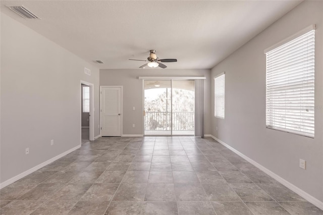 tiled empty room featuring ceiling fan