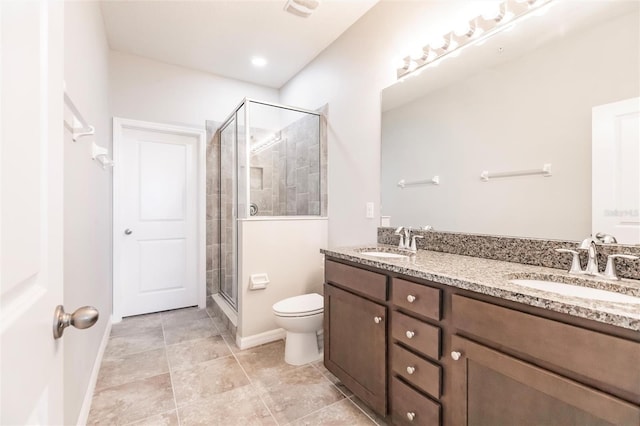 bathroom featuring vanity, toilet, and a shower with door