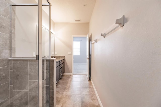 bathroom with tile patterned flooring, vanity, and a shower with shower door