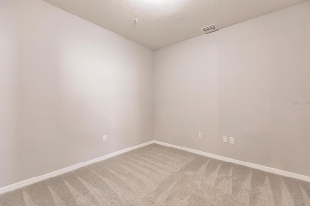 unfurnished room featuring carpet flooring and a textured ceiling