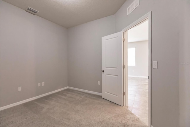 carpeted spare room featuring a textured ceiling