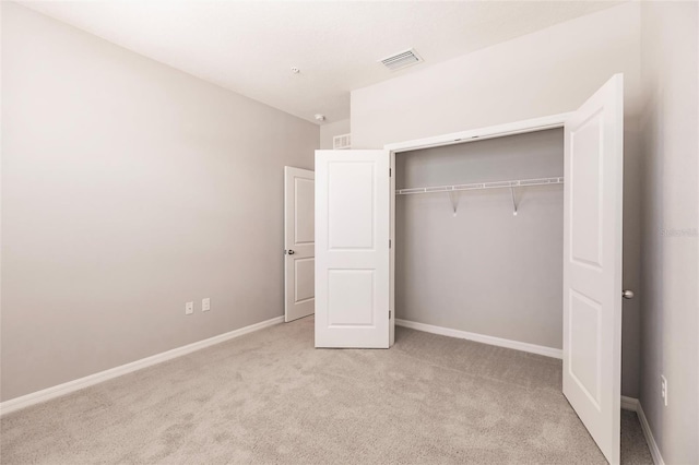 unfurnished bedroom featuring a closet and light colored carpet