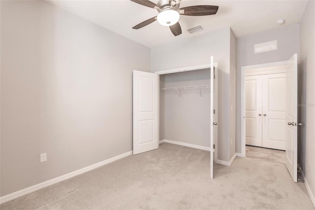 unfurnished bedroom featuring ceiling fan, a closet, and light colored carpet