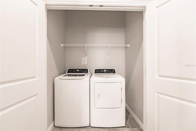 laundry area featuring washer and clothes dryer and tile patterned flooring