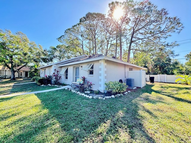 view of side of property featuring a lawn and cooling unit