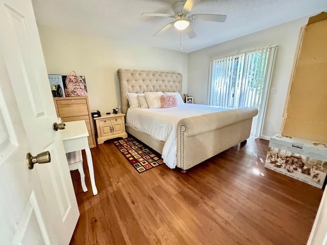 bedroom with a textured ceiling, dark hardwood / wood-style flooring, and ceiling fan