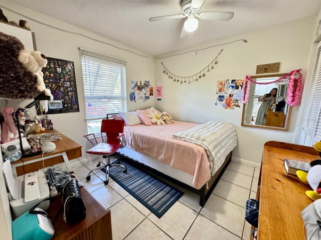 bedroom featuring light tile patterned floors, a textured ceiling, a closet, and ceiling fan