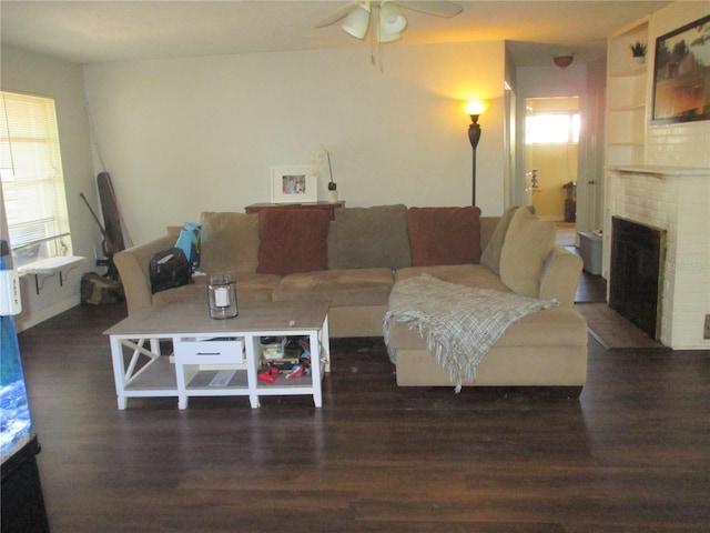 living room featuring ceiling fan, dark hardwood / wood-style flooring, and a brick fireplace