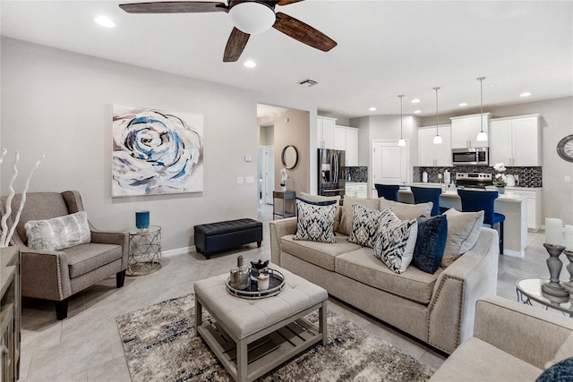 living room with light tile patterned floors and ceiling fan