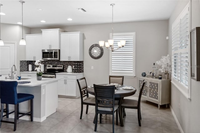 kitchen featuring decorative light fixtures, stainless steel appliances, a wealth of natural light, and sink