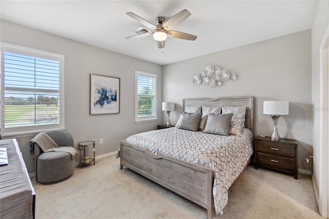 bedroom with multiple windows, ceiling fan, and light carpet