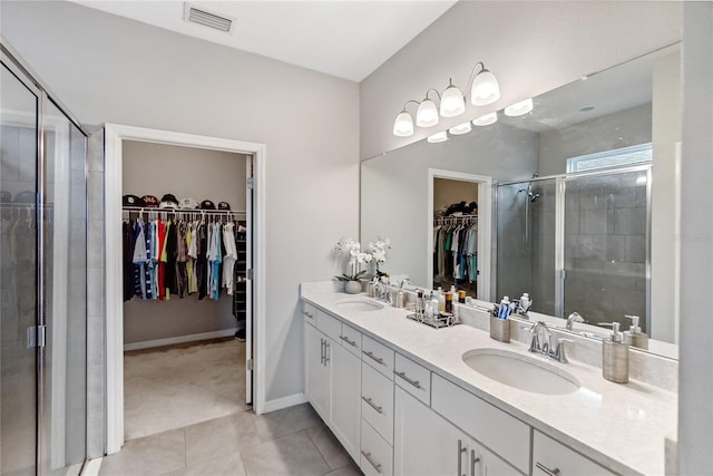 bathroom with tile patterned floors, vanity, and a shower with shower door