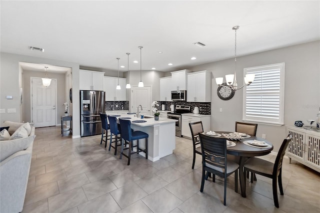 tiled dining area with sink and a notable chandelier